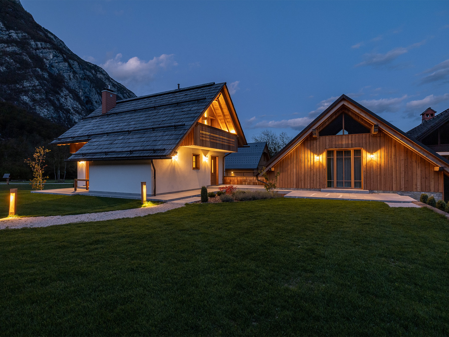 Alpine SPA Chalet illuminated at dusk in its mountain setting in Ukanc near Lake Bohinj.
