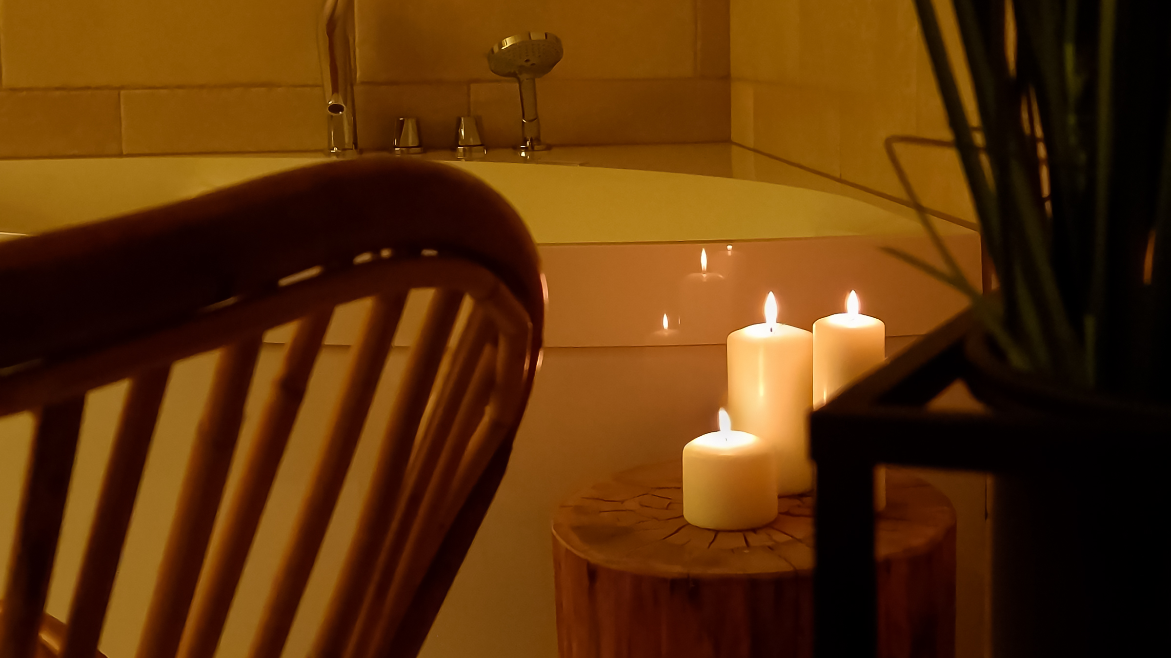 Candlelight beside the whirlpool bath in the private wellness area of the Alpine SPA Chalet by Lake Bohinj.