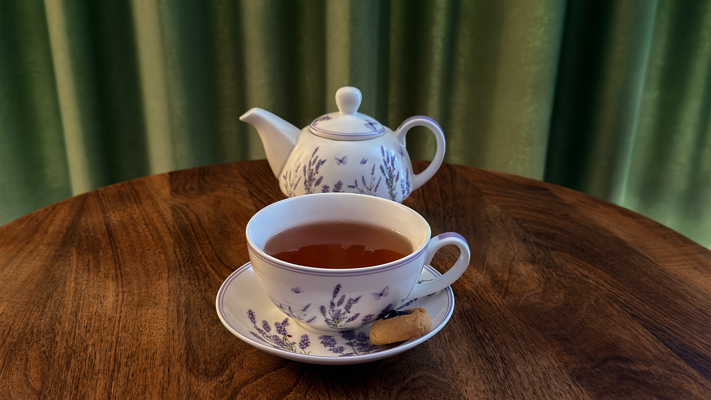 Cup of herbal tea with a lavender-patterned teapot inside the Alpine SPA Chalet by Lake Bohinj.